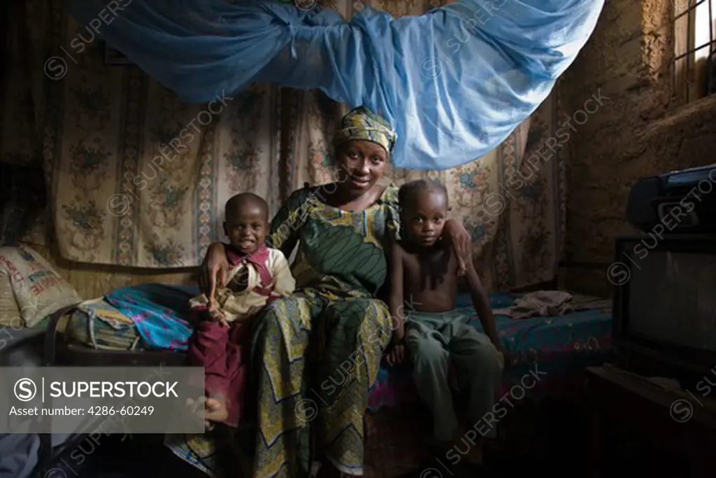 Mother and children with mosquito net in Kano, Nigeria.  Sleeping under a long lasting insecticide treated net every night prevents malaria.  Malaria, which is transmitted through the bite of an infected mosquito, is a major killer of children under five and pregnant women in Nigeria and the developing world. NOT MODEL RELEASED. EDITORIAL USE ONLY.