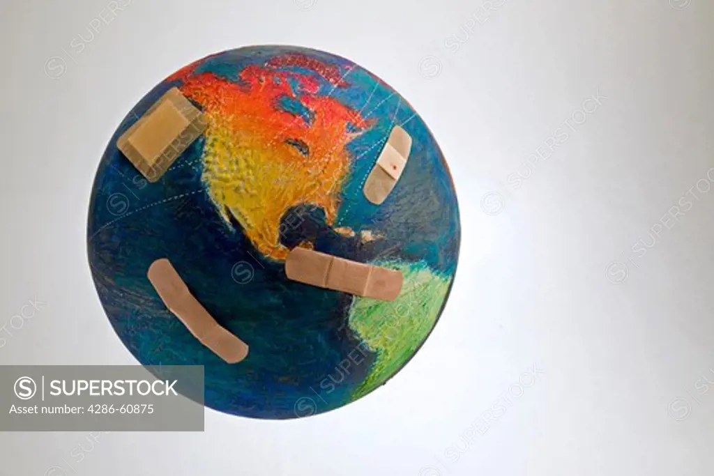 Still shot of a world globe with band aids on the Oceans and Central America