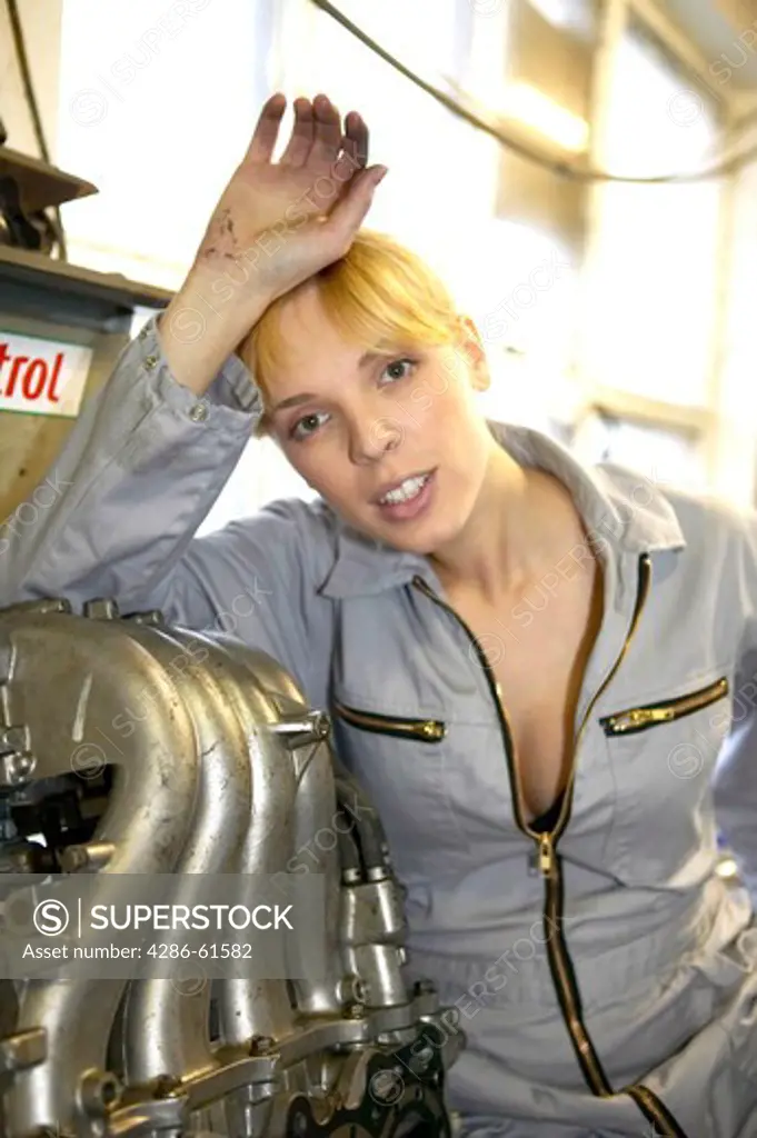 female motor mechanic working on the car motor