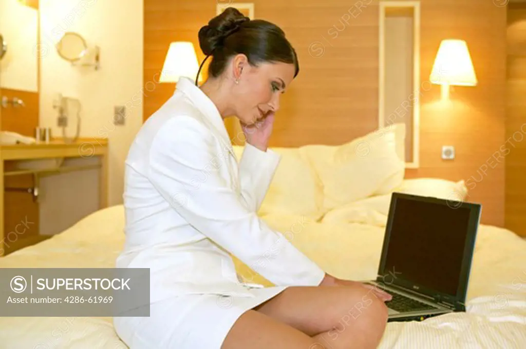 young woman in suit working on notebook in hotel room