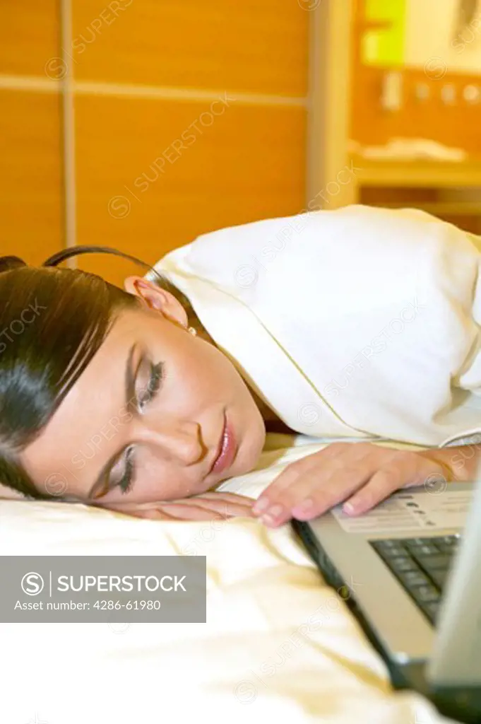 Tired female manager with laptop in a hotel room