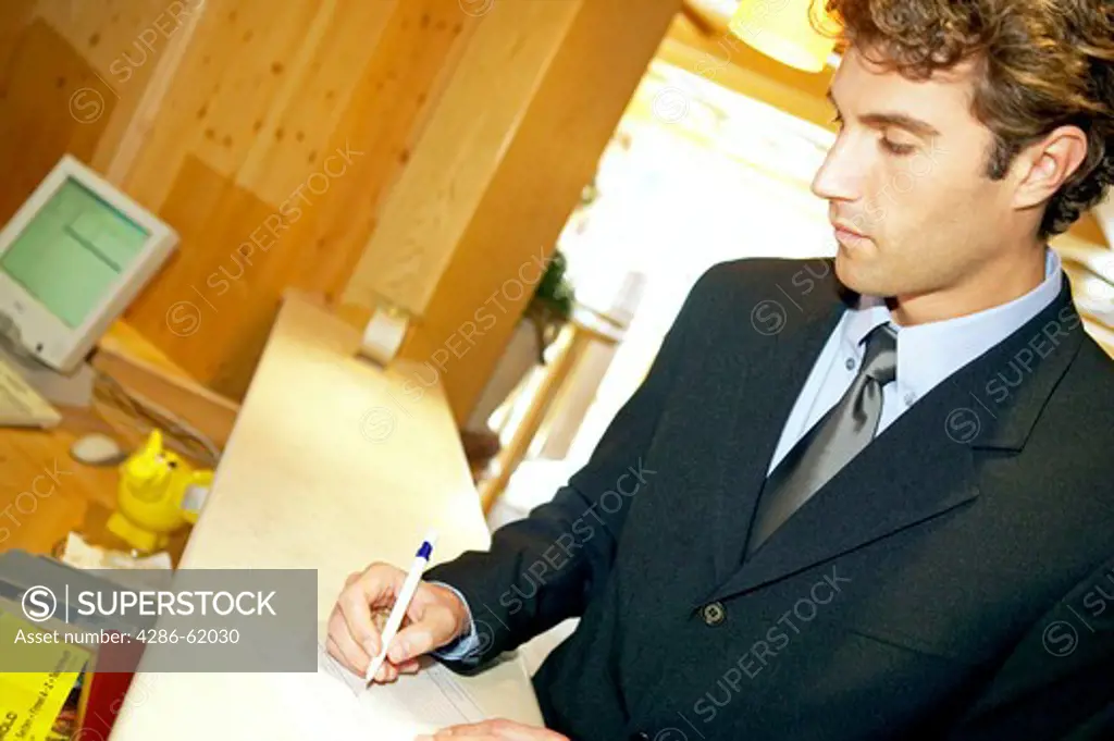 Man checking in paying at the reception desk