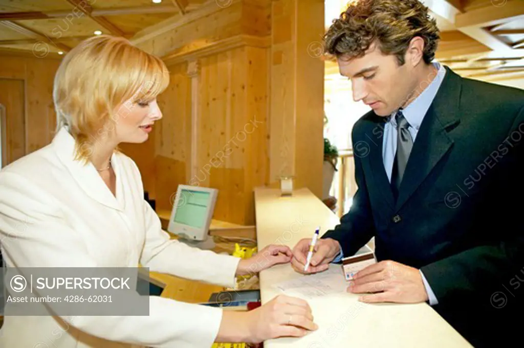 Man checking in paying at the reception desk