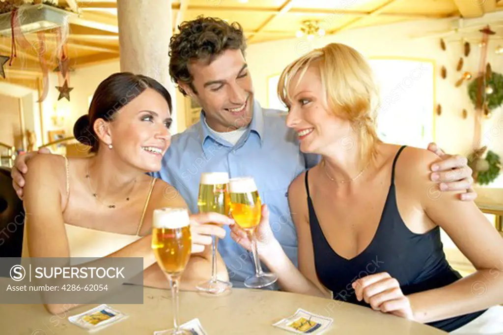 Man flirting with two women at a hotel bar
