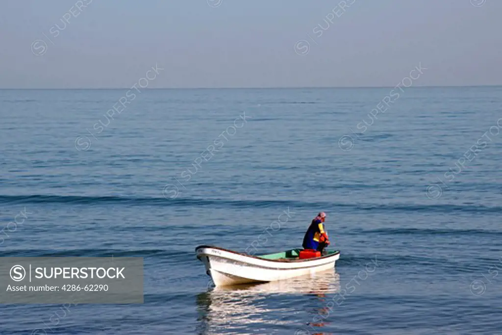 Oman Fischer in his boot on the sea. fisherman at sea