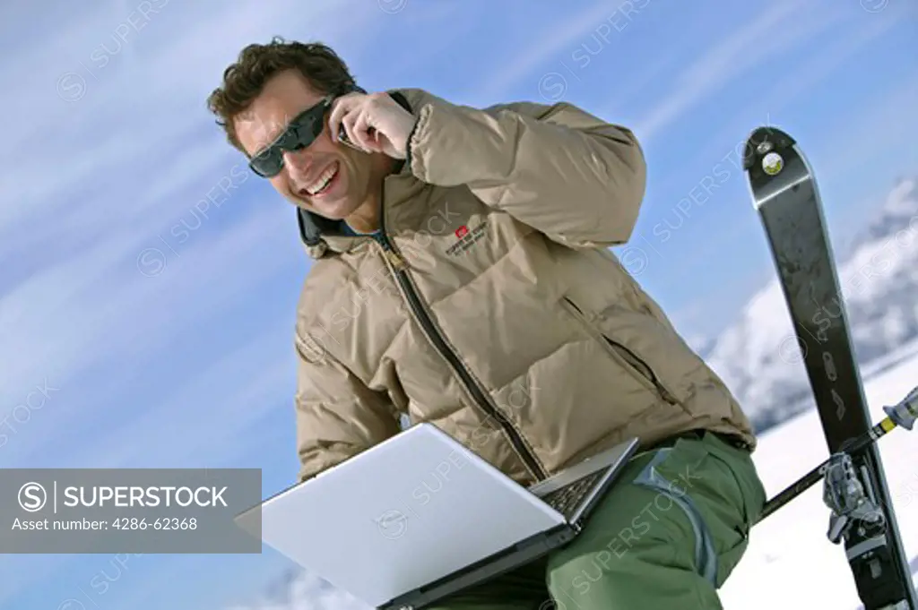 man with notebook and mobile at winter holiday