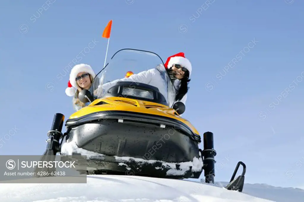 two women on snowmobile, skiscooter