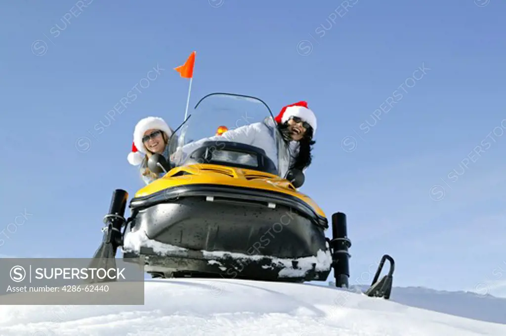 two women on snowmobile, skiscooter