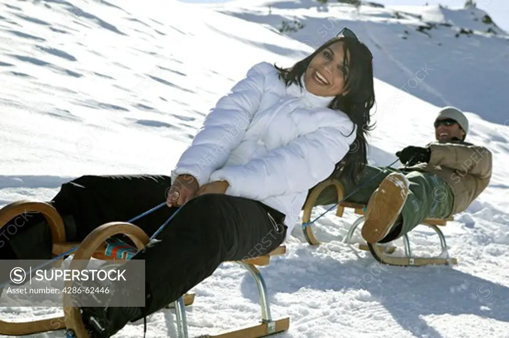 Couple Sledging in Mountains Winter Holiday