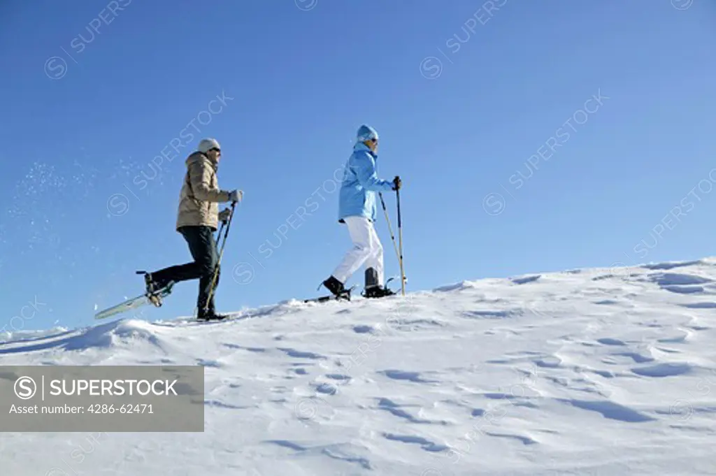 couple in winter hiking with snow shoes