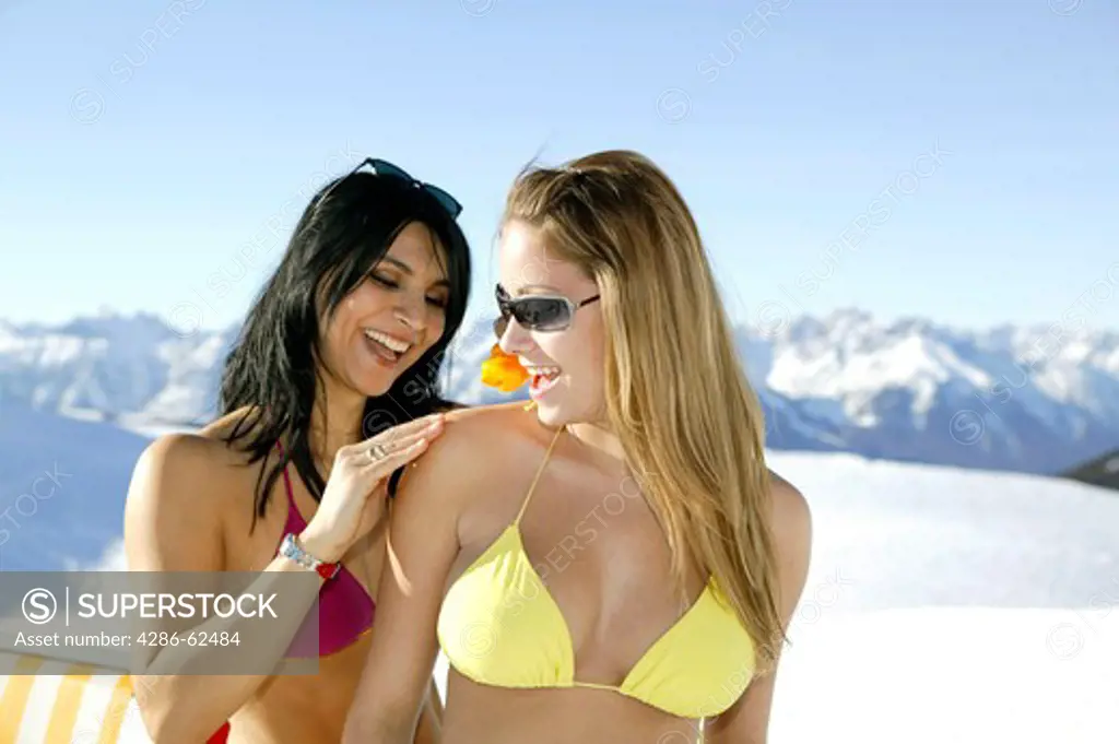 two woman sun bathing in winter holiday