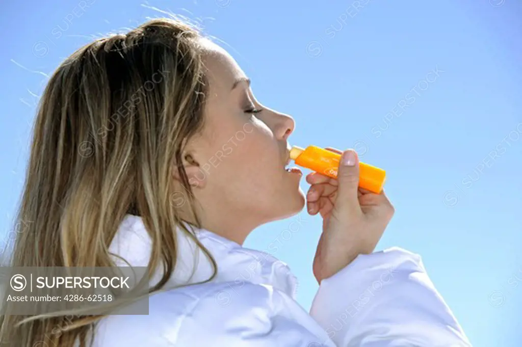winter holiday woman putting sun cream on her lips