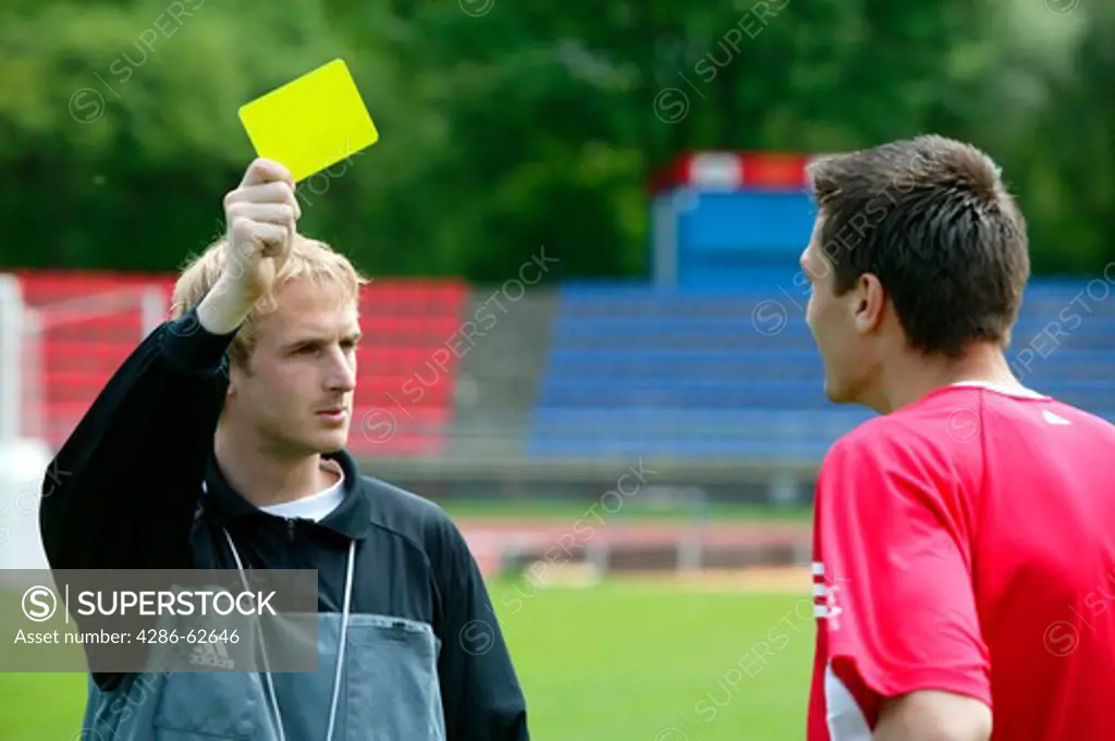 soccer referee showing the yellow card