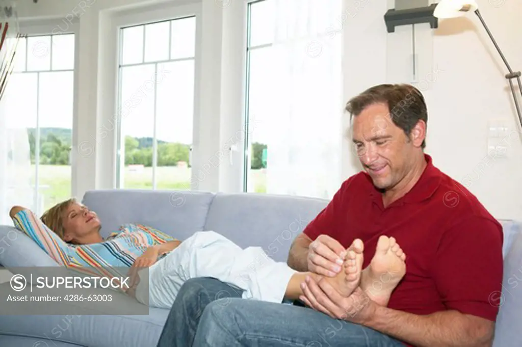 man massaging feet of his wife