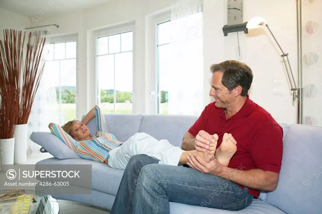 man massaging feet of his wife