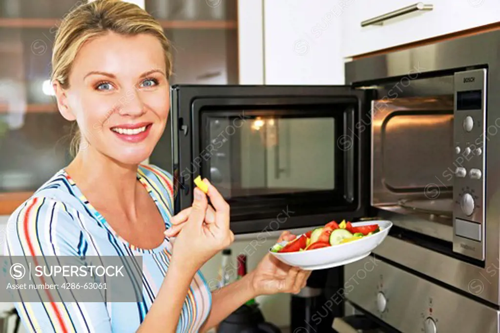 woman in kitchen use microwave