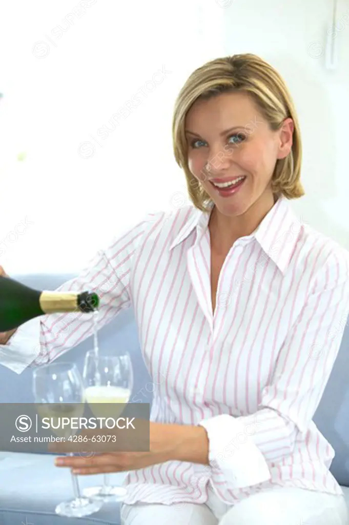woman filling champagne into 2 glasses