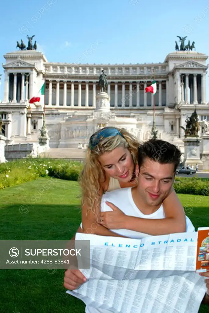 Young pair with map on Piazza Venezia near MonumentVittorio Emanuele II