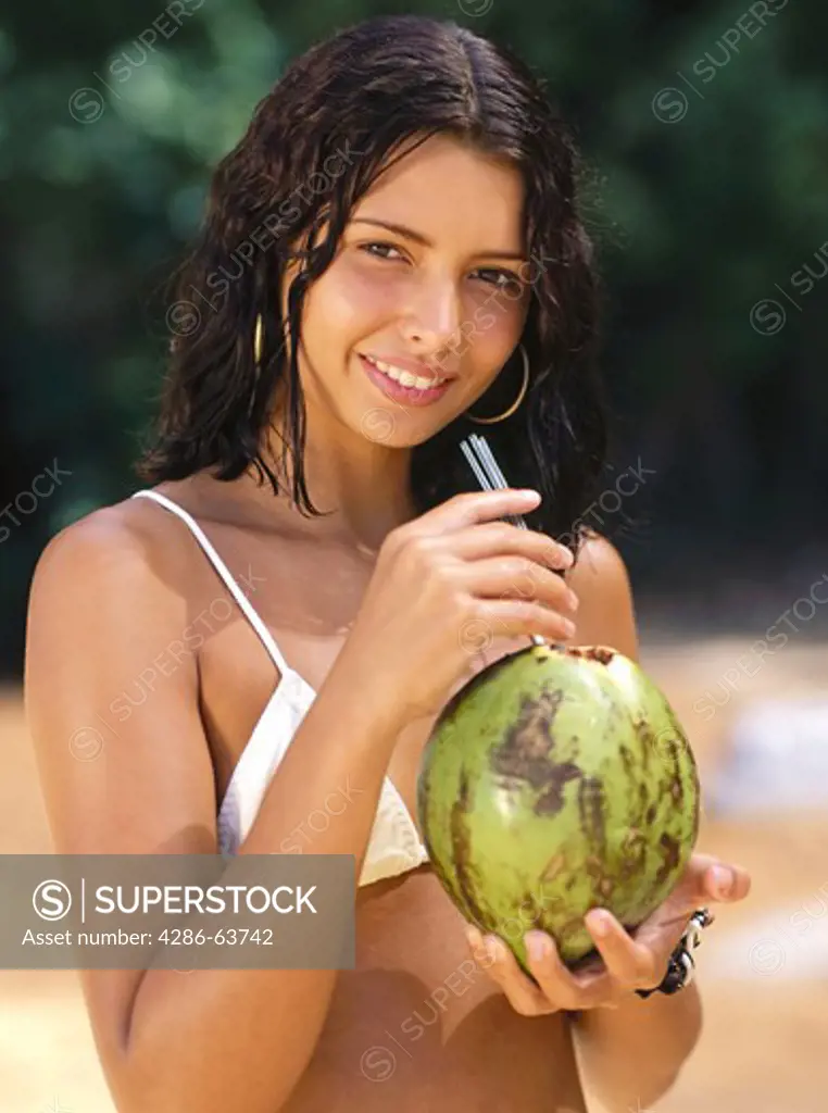 Woman drinks from coconut