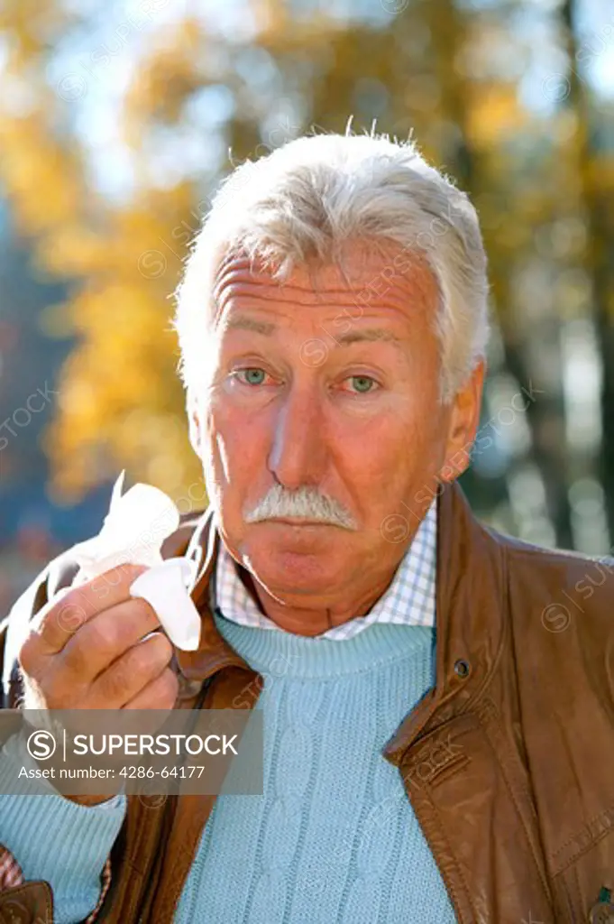 older man in autumn having a cold