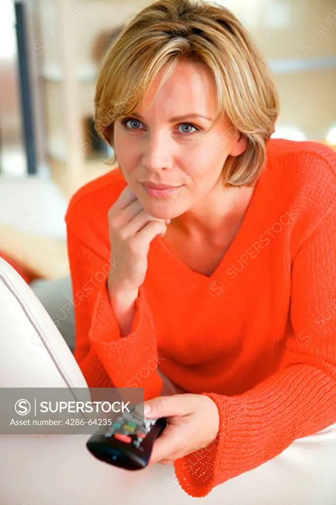 blond woman at home with remote control