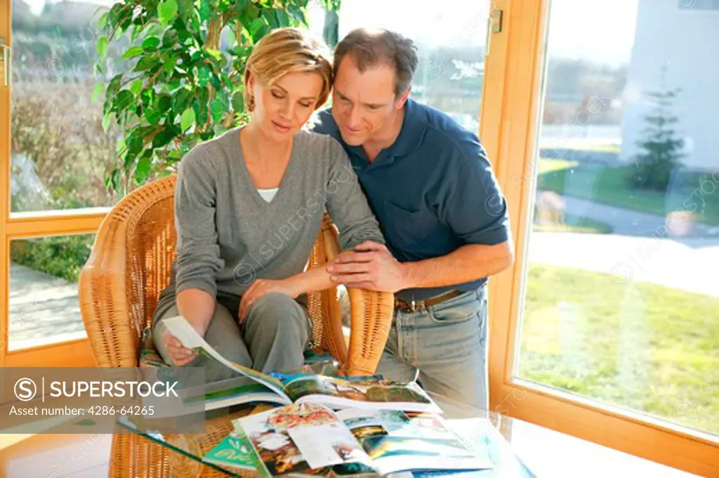 couple at home looking at travel ads