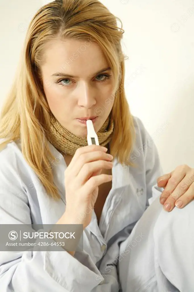 Woman with fever thermometer, cold