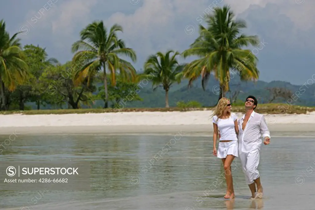 couple in love walking at tropical beach in