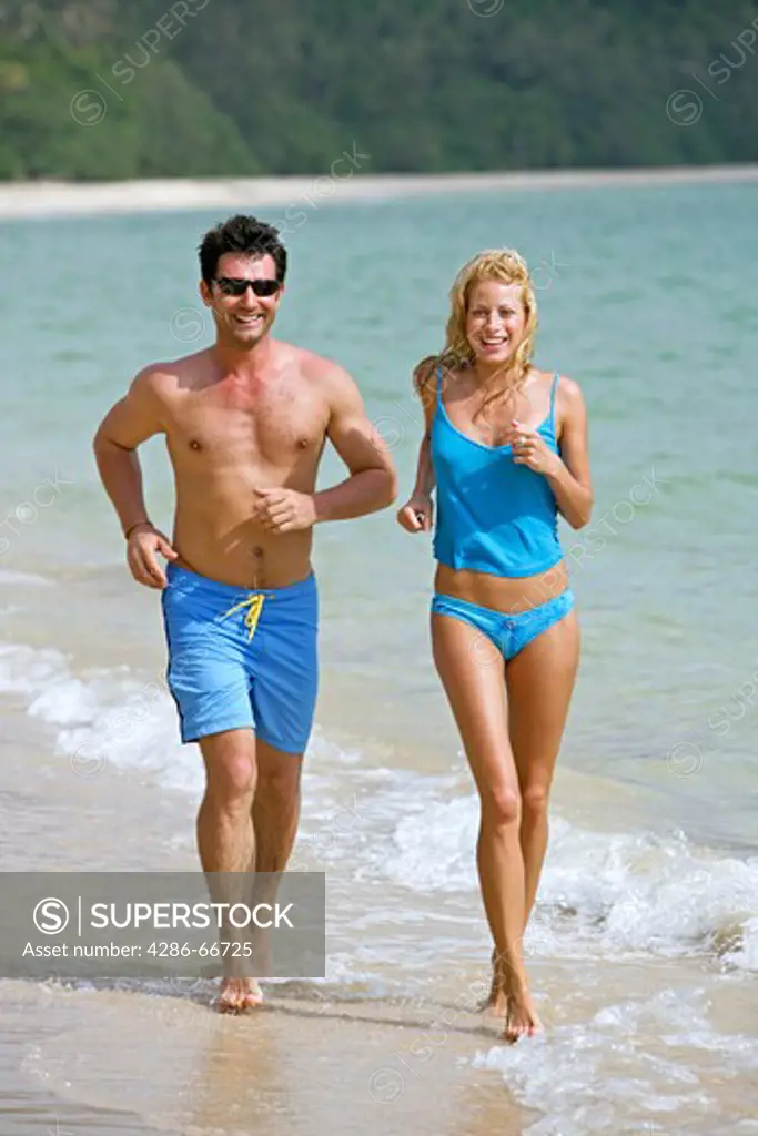 couple jogging on the beach at yao yai island resort