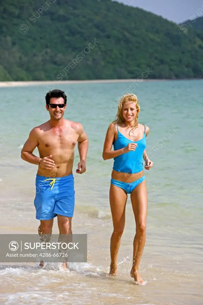 couple jogging on the beach at yao yai island resort
