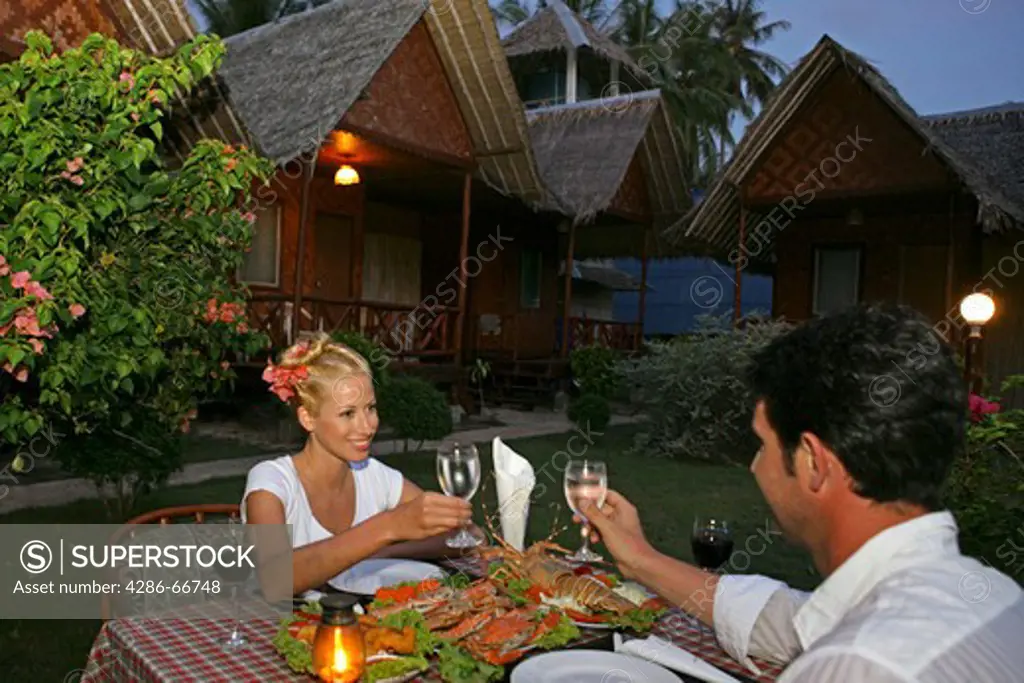 couple in love enjoying seafood at restaurant in yao yao island resort