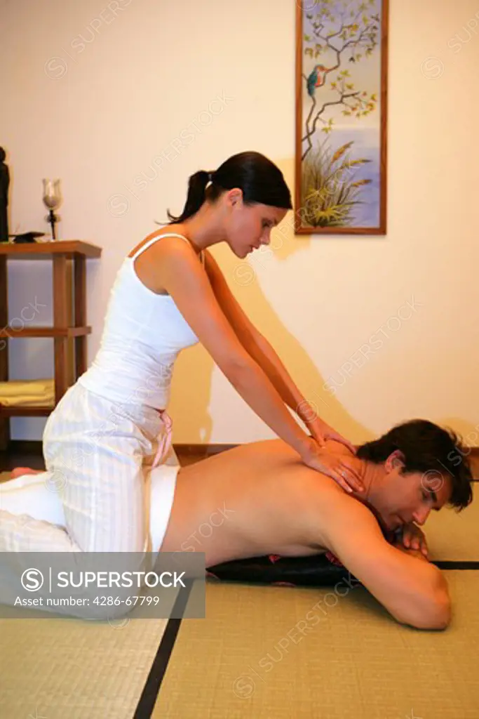 man enjoying massage from his wife, girlfriend