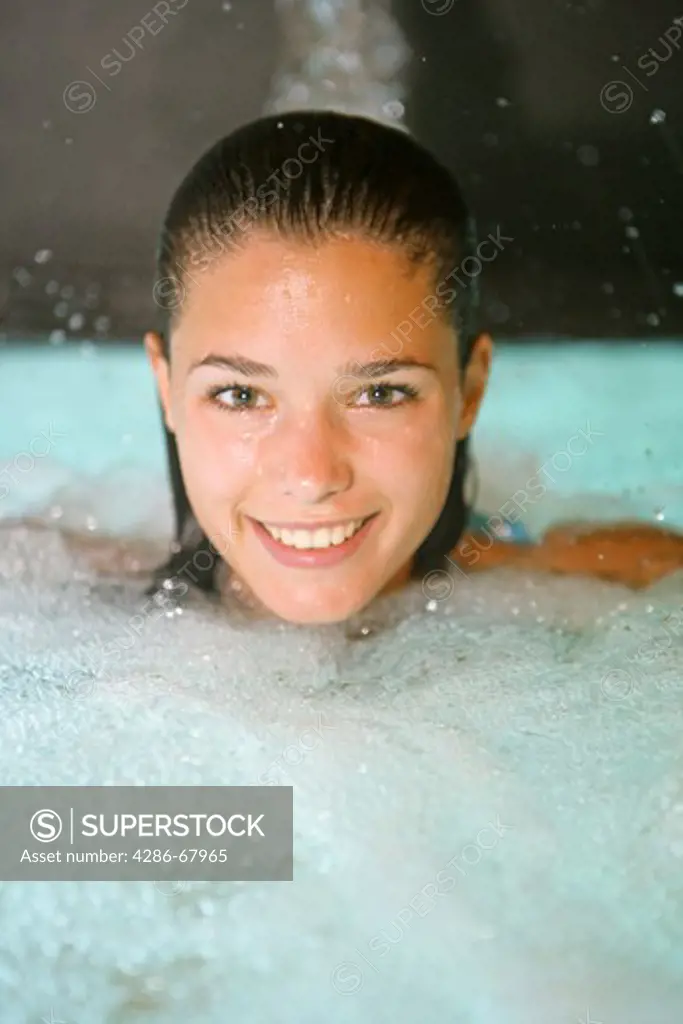 Young woman relaxe in a swimming pool at a spa