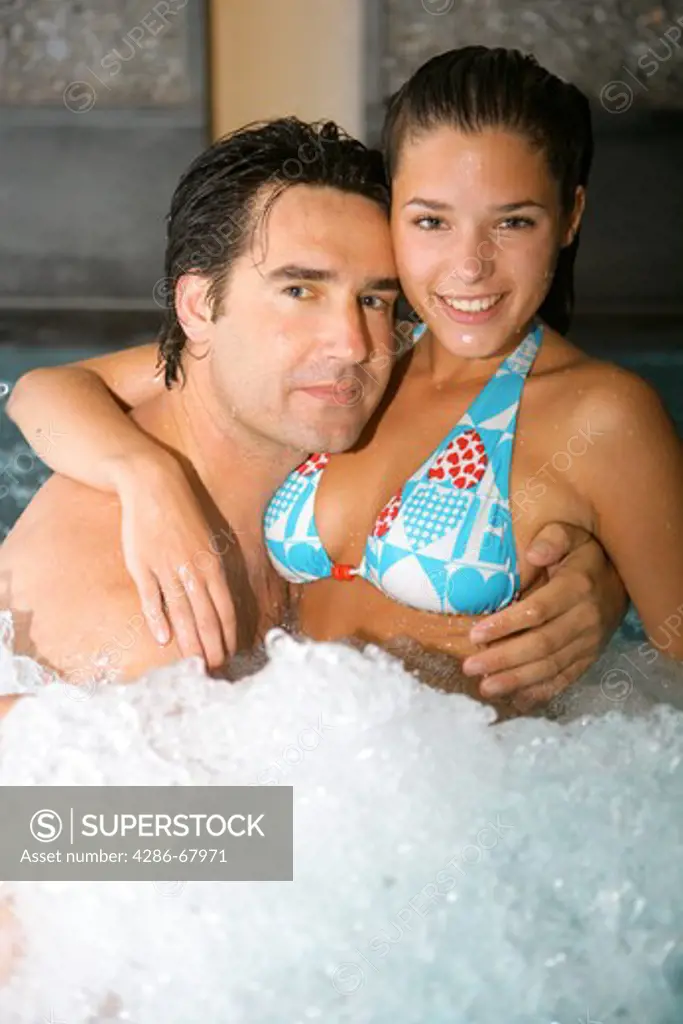 couple in love relax in a swimming pool at a spa hotel
