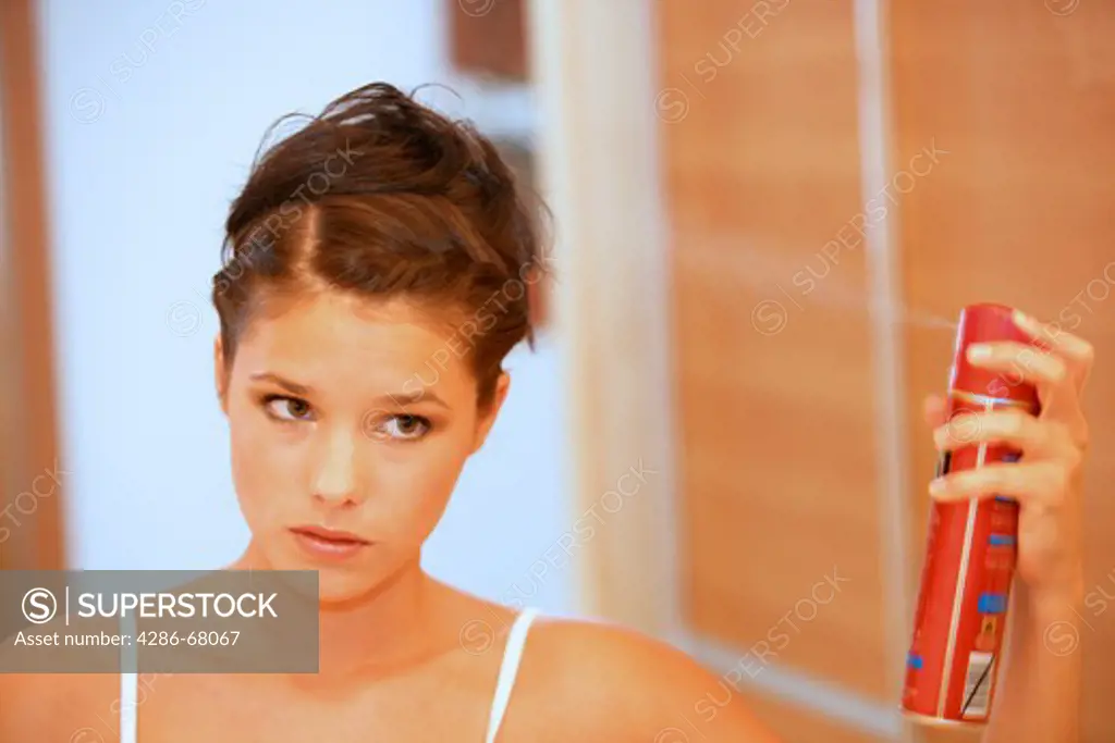 young woman using hairspray