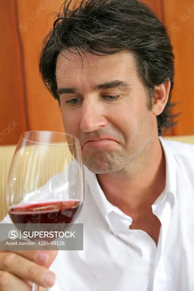 Man drinking red wine in a restaurant