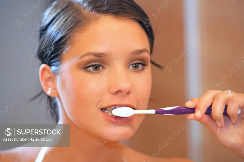 a young woman brushing her teeth