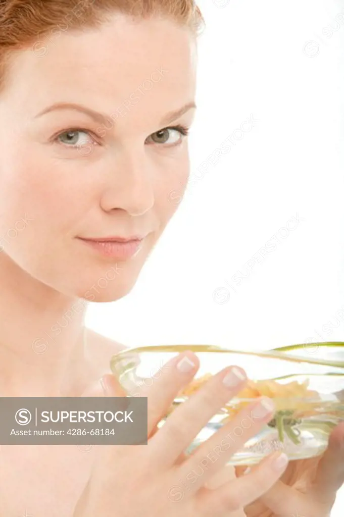 Woman smelling aromatherapy bowl with flowers