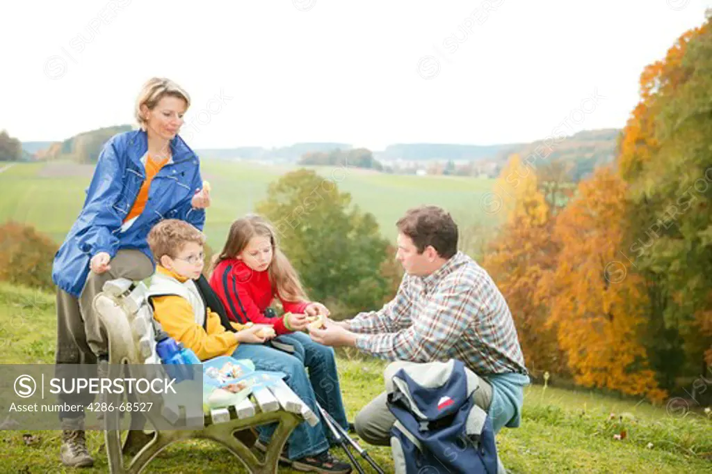 A family strolls through the woods on an autumn day