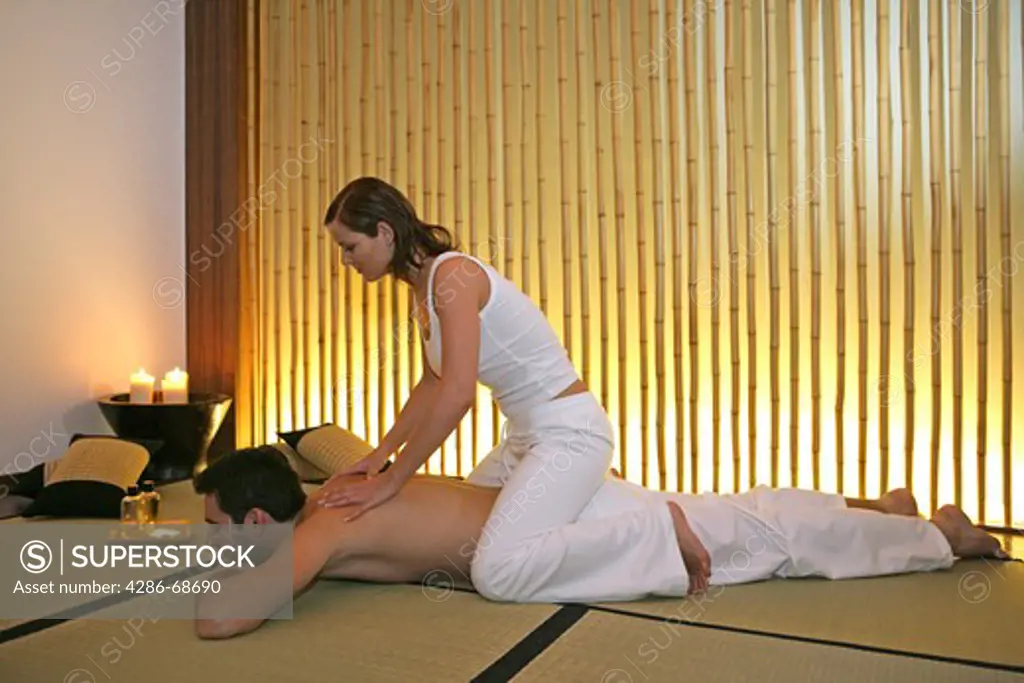 Man enjoying massage from his wife, girlfriend