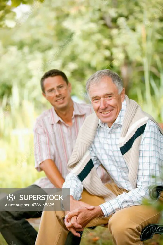 Elderly father and adult son in garden