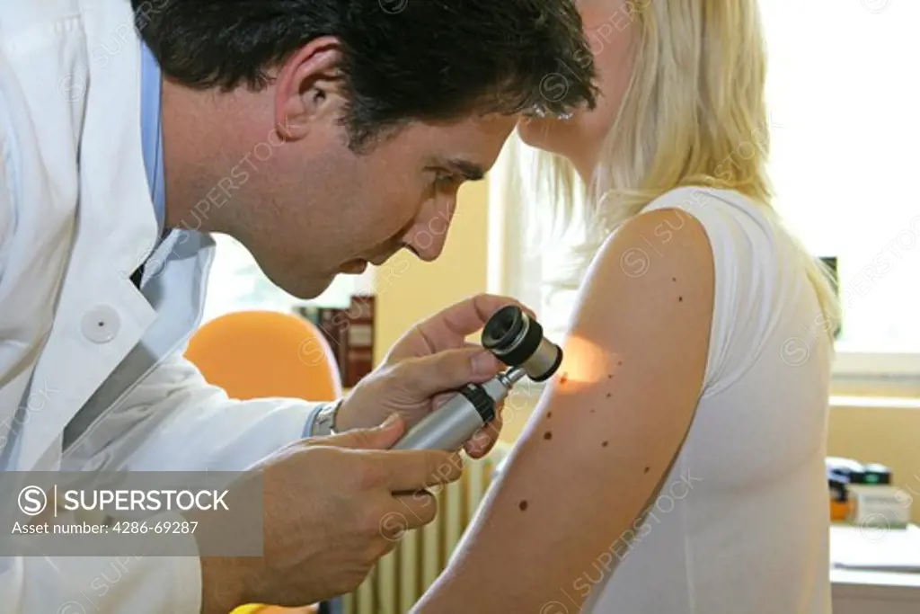 A dermatologist examines a patient for skin cancer