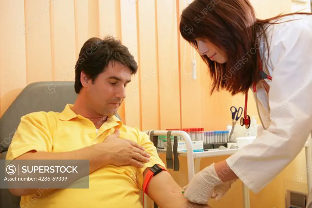 female doctor taking blood sample from hospital patient