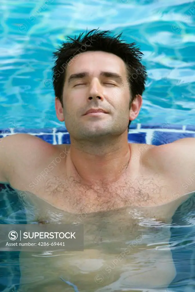 man relaxing on pool in summer holiday, portrait