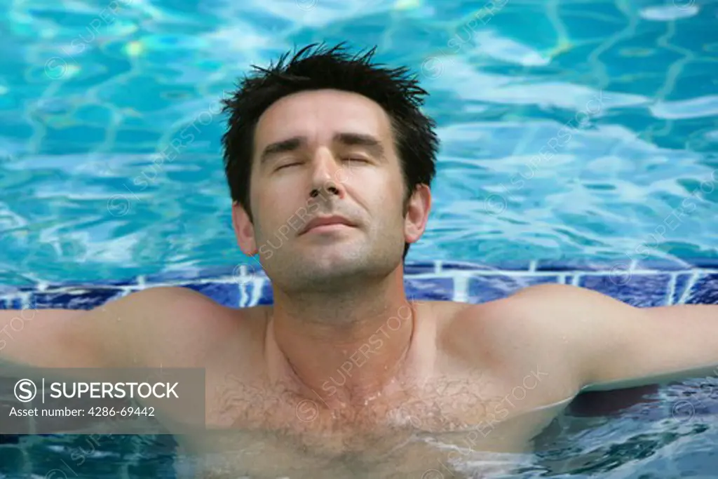 man relaxing on pool in summer holiday, portrait