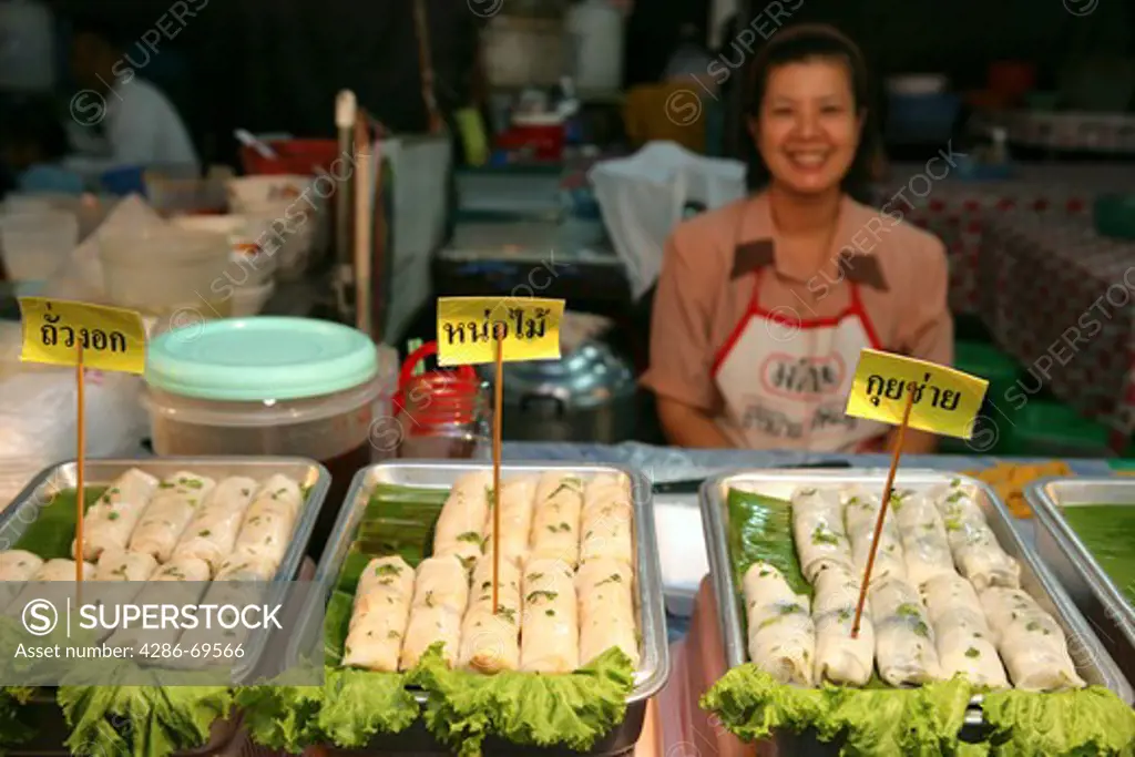 woman sales thai food on market in