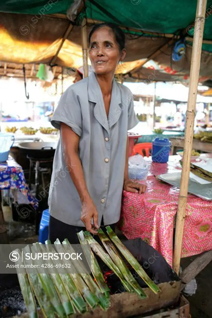 woman sales thai food on market in