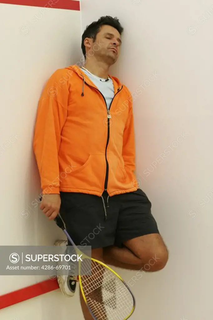 Tired man with squash racquet