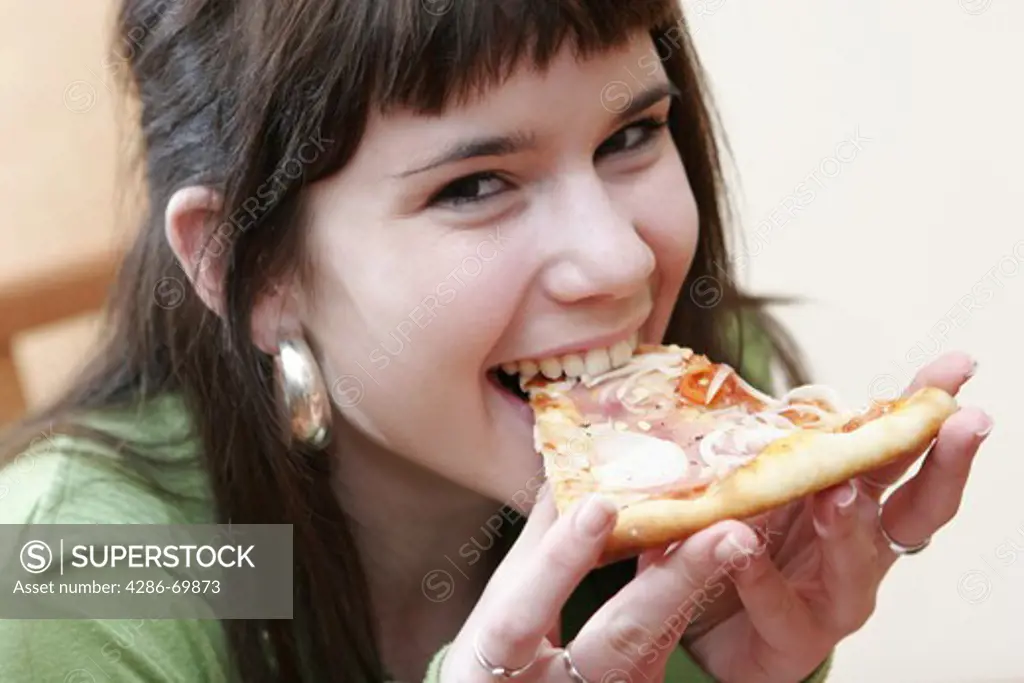 Girl, teenager eats a piece of pizza