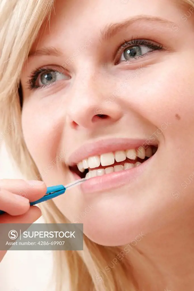 Young woman with the tooth clean with an interdental brush